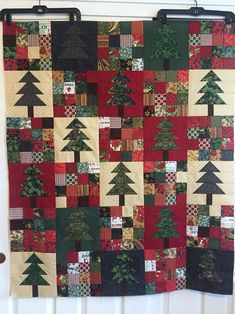 a quilted christmas tree is hanging on the wall