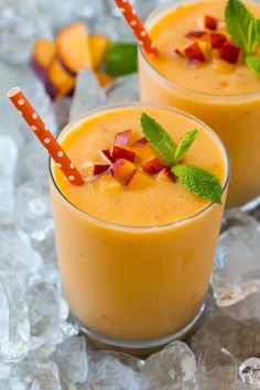 two glasses filled with orange smoothie and garnished with mint