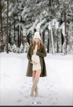 a woman is standing in the snow wearing boots