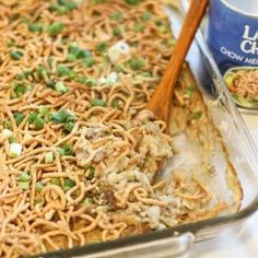 a casserole dish with noodles, meat and vegetables in it next to a can of chow mein