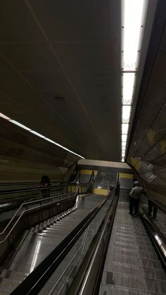 an escalator with two people walking up and down it