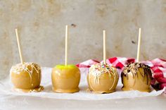 four caramel apples with sprinkles on them