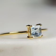 This beautiful princess cut aquamarine ring was handmade in Melt’m Jewelry Studio in California, using 14k solid yellow gold band and 4mm princess cut aquamarine stone in 14k yellow gold prong setting. Aquamarine is the anniversary gemstone (especially for the 16th and 19th year of marriage) and March birthstone (a shiny, blue sky March Birthday present!). Aquamarine is a symbol of beauty, honesty, and courage. If you have any questions about this item, please hit the “Ask a Question” button nex Promise Princess Cut Birthstone Ring, Princess Cut Birthstone Promise Ring, Fine Jewelry Princess Cut Solitaire Birthstone Ring, Princess Cut Solitaire Topaz Ring For Anniversary, Yellow Gold Princess Cut Sapphire Ring, Classic Blue Topaz Ring With Princess Cut, Classic Blue Topaz Princess Cut Ring, Classic Princess Cut Blue Topaz Ring, Yellow Gold Sapphire Princess Cut Promise Ring