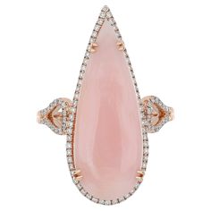 Elegant and exquisitely detailed Gold Ring, center set with 6.38 Cts Pear Shape Pink Opal surrounded by and enhanced on shank with micro pave Diamonds, weighing approx. 0.32 Cts total carat weight. Beautifully Hand crafted in 14 Karat Rose Gold. Stone Details: Pink Opal: 26X10MM Stone Weight: Pink Opal: 6.38Cts Diamond: GH-SI Total Diamond Weight: 0.32Cts Ring Size: US 7 Customizable based on request. Free Engraving available. Pink Opal Ring, Pink Studs, Gold For Sale, Rose Gold Pink, Gold Work, Gold Stone, Opal Ring, Jewelry Companies, Pink Opal