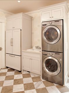 a large laundry room with two washers and dryer combos in the corner