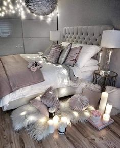 a bed with pillows and blankets on top of it in a room filled with lights