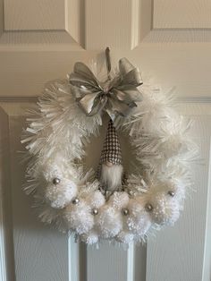 a white wreath hanging on the front door