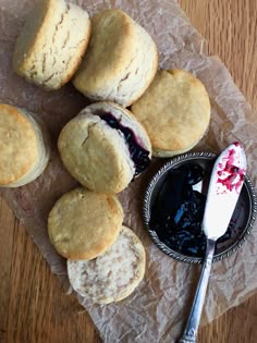 biscuits and jam on wax paper next to a spoon