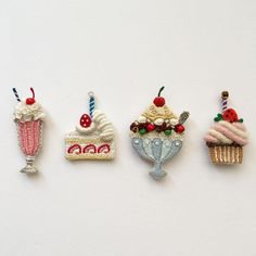 three miniature cakes and two cupcakes are hanging on the wall