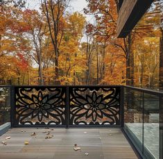 an outdoor deck with railings and autumn trees in the backgroung area