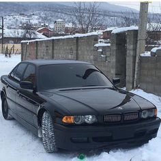 a black car is parked in the snow