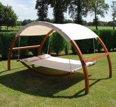 a swing bed in the middle of a grassy field