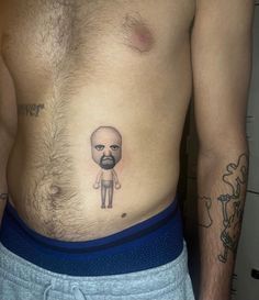 a man with a balding head and beard on his stomach has a small tattoo