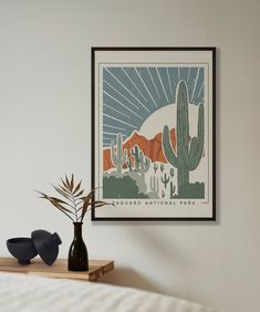 a poster hangs on the wall above a bed with a vase and plant in it