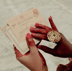 a woman with red nails holding up a piece of paper