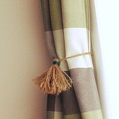 a curtain with a tassel hanging from it's side next to a window