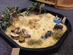 an animal habitat is shown in the middle of a room with toys and fake trees