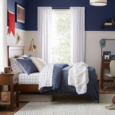 a bedroom with blue walls and white curtains