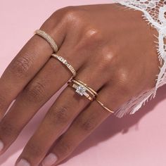 a woman's hand with three different rings on her left and the other one is wearing