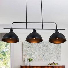 three lights hanging over a dining room table