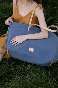 An upscale market tote that functions as well as it looks, the Hana Canvas Boat Bag is a unique and beautiful carryall. Made of heavy-weight canvas in hand-dyed hues that capture the changing light of warm afternoons. Triple wash techniques bring out a relaxed sun-kissed softness to the heavy gauge canvas, while hand-frayed deconstructed edges remind us to let our hair down. The Hana Canvas Tote features sturdy vegetable-tanned leather shoulder straps and trim on the base seams, a nickel snap cl Boat Bag, Commute To Work, Hair Down, Market Tote, Sun Kissed, Down Hairstyles, Vegetable Tanned Leather, Sock Shoes, Leather Handle