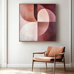 a chair sitting in front of a painting on the wall