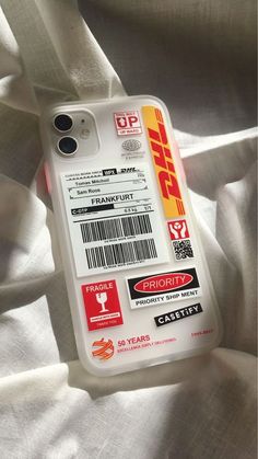 a cell phone case that is on top of a white sheet with red and yellow stickers