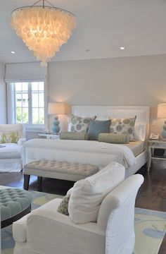 a large white bed sitting in a bedroom on top of a hard wood floor