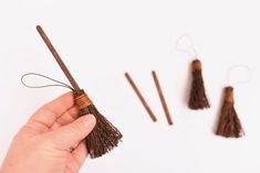 a person is holding three small brown tassels