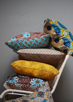 a stack of pillows sitting on top of a white chair