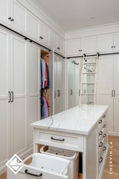 A white walk-in closet with a rolling ladder and Closet Pull Out, Closet With Middle Island, Master Closet Center Island, Closet With Ladder Small Spaces, Walk In Closet Design With Island, Walk In Closet Seating Ideas, Condo Walk In Closet Ideas, Small Closet With Island