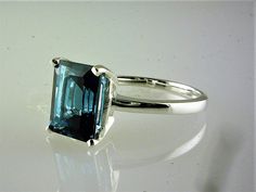 All our jewelry is handcrafted in the U.S.A Lovely as the clear, radiant blue of deep blue seas... This exquisitely cut emerald cut London Blue Topaz is a nice size-- not too big and not too small a full 4.06 carats-- catching the light. This ring is sure to capture the attention of many admiring glances. And this great solitaire design fully shows the beauty of the the London Blue Topaz. Set in solid .925 sterling silver. You will love it... Emerald cut 10x8 MM - 4.06 Carats If you need this it Cute Engagement Rings, Heart Melting, Blue Topaz Ring, London Blue Topaz, London Blue, Topaz Ring, The London, White Topaz, Solitaire Ring