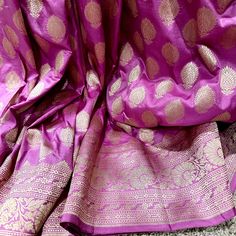 This stunning pink 100% Mulberry Katan silk saree is handwoven in Banaras, known for its intricate designs and high-quality craftsmanship. The saree features a beautiful shade of dual - pinkish purple with golden zari jaal work, creating a mesmerizing effect. The saree is perfect for any special occasion, such as a wedding, festival, or formal event. Comes finished with hand fall and Pico. And a blouse piece with zari border. Silk Mark Certified Note: Colors that show up on your screen may vary slightly from the actual product due to variations in settings. Also, the actual product may appear to be different hues depending on the ambience lighting.Note: There may be very slight inconsistencies such as in the weave/motiff work or color , there being characteristics are not considered defect Festive Purple Katan Silk Traditional Wear, Pink Raw Silk Traditional Wear For Ceremonies, Traditional Drape Blouse Piece In Pink For Celebrations, Pink Saree For Celebration With Traditional Drape, Pink Traditional Drape Blouse Piece For Celebration, Traditional Drape Pink Blouse Piece For Celebration, Pink Blouse Piece For Celebration, Purple Raw Silk Dupatta With Zari Weaving, Purple Katan Silk Blouse With Traditional Drape