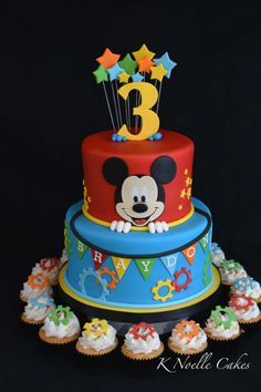 a mickey mouse birthday cake with cupcakes on the bottom and stars around it