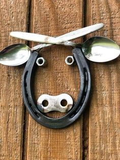 a metal cow head with spoons attached to it