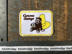 a patch on the side of a piece of wood with a monkey holding a banana