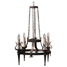 a chandelier with candles hanging from it's arms and chains on the bottom