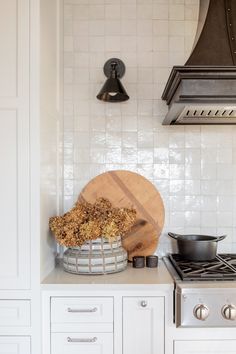 a wooden cutting board sitting on top of a counter next to a pot and pan