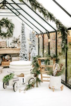 an indoor greenhouse decorated for christmas with wreaths and greenery