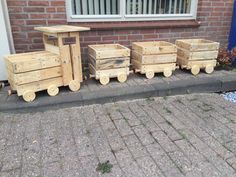 three wooden crates sitting next to each other on the side of a road in front of a brick building