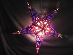 a purple and red lighted star hanging from the ceiling