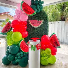 a watermelon themed birthday party with balloons and decorations on the side of it