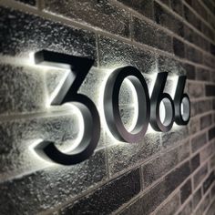 an illuminated sign on the side of a brick building reads 350 degrees, and it is lit up at night