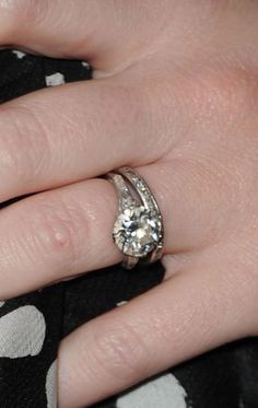 a woman's hand with a diamond ring on her left and an engagement band on her right