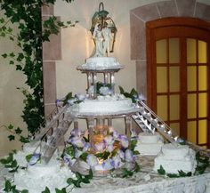 a white table topped with a tiered cake covered in frosting and greenery