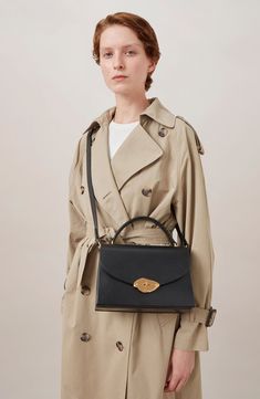 The label's new Foundry Lock—a daliesque twist on their iconic Postman's Lock—distinguishes this structured top-handle bag crafted in high-shine leather. Turnlock closure Top carry handle; removable, adjustable crossbody strap Exterior slip pocket Interior wall pocket Structured silhouette with flat base for stability Napa-leather lining Leather Made in Turkey Designer Handbags Designer Double Flap Satchel For Formal Occasions, Designer Double Flap Satchel For Formal Events, Elegant Satchel With Round Handle For Work, Elegant Workwear Satchel With Round Handle, Elegant Double Flap Shoulder Bag With Top Carry Handle, Elegant Double Flap Shoulder Bag With Top Handle, Elegant Top Handle Satchel With Turn-lock Closure, Elegant Satchel With Turn-lock Closure And Top Handle, Elegant Evening Satchel With Turn-lock Closure