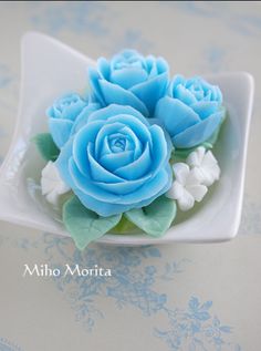 there is a small blue rose on a white plate