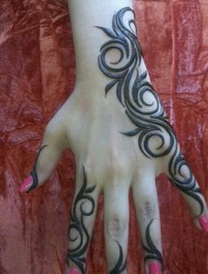 a woman's hand with black and white designs on the palm, which is decorated with pink nail polishes