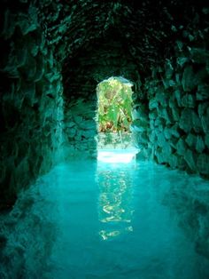 an image of the inside of a cave with blue water and rocks on either side