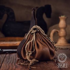 a brown purse sitting on top of a wooden table